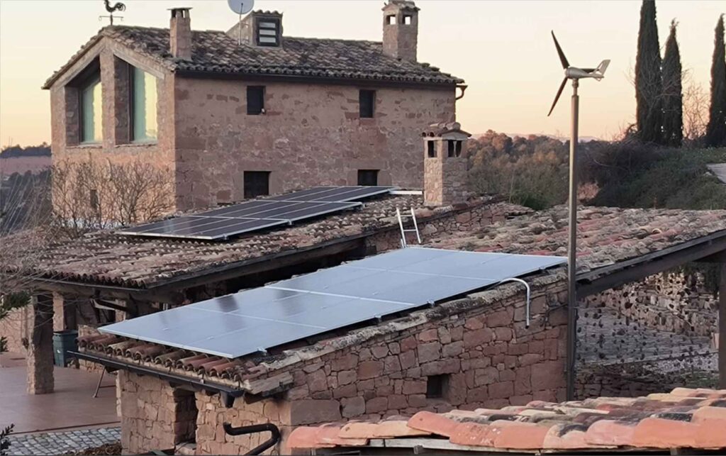 Instalación de placas solare y molino eólico para auto abastecimiento de energía en una masía.
